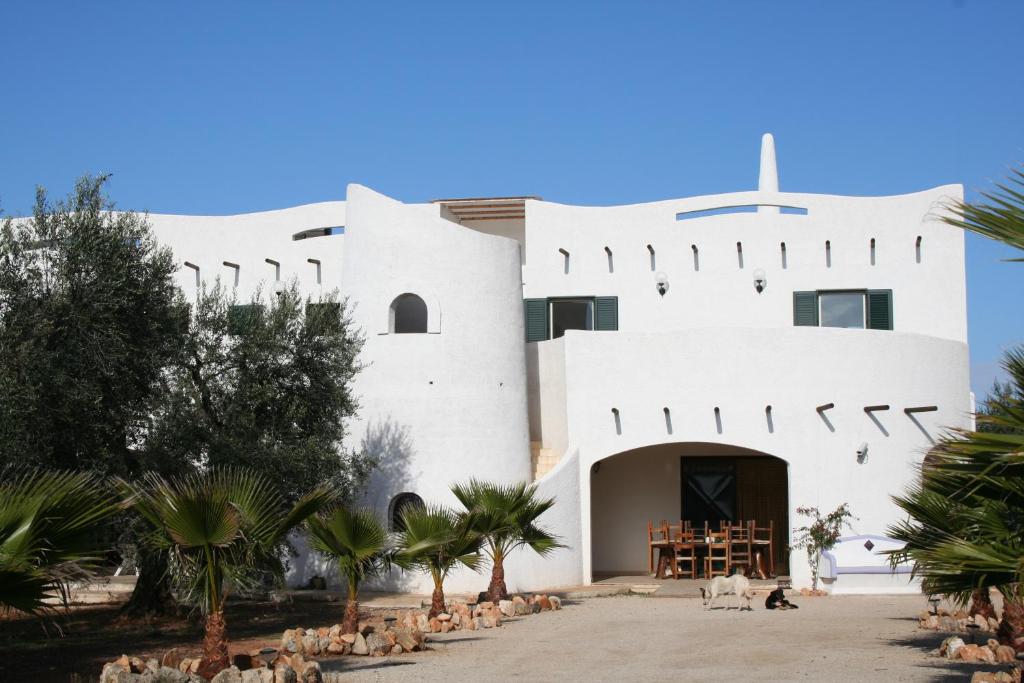 un edificio blanco con pájaros delante de él en Agriturismo Tenuta Del Morige, en Galatone