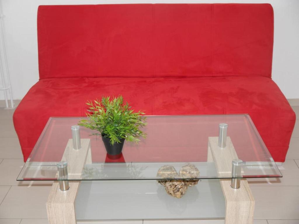 a red couch with a glass table and a red couch at Seehütte Ferienwohnung 505 in Cuxhaven