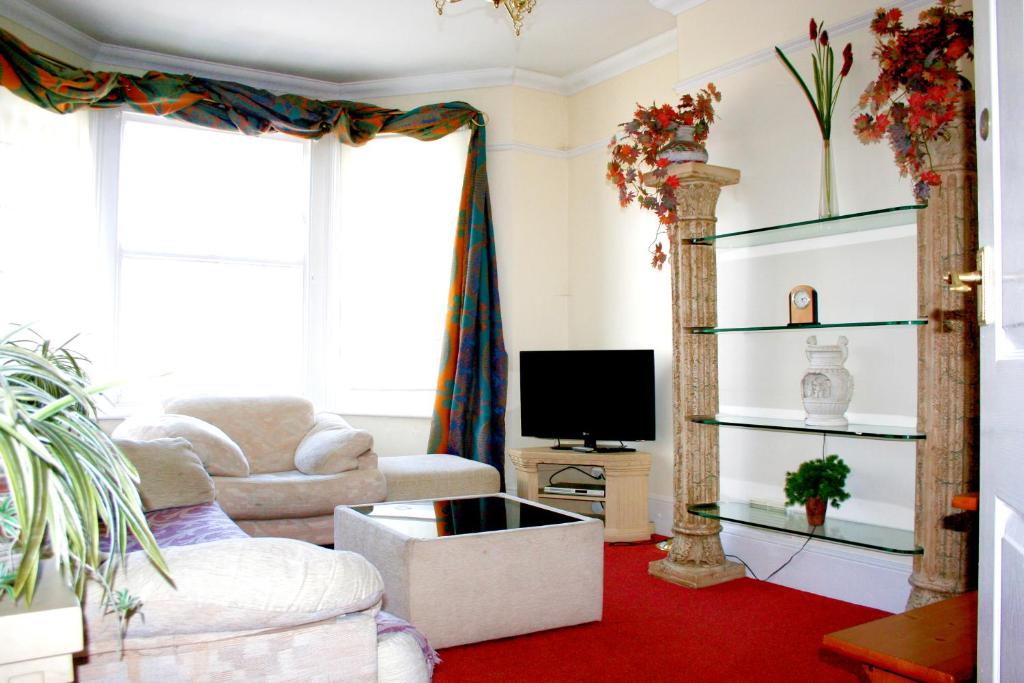 a living room with a tv and a red carpet at Hartland Apartments - near Cliffs Pavilion in Southend-on-Sea