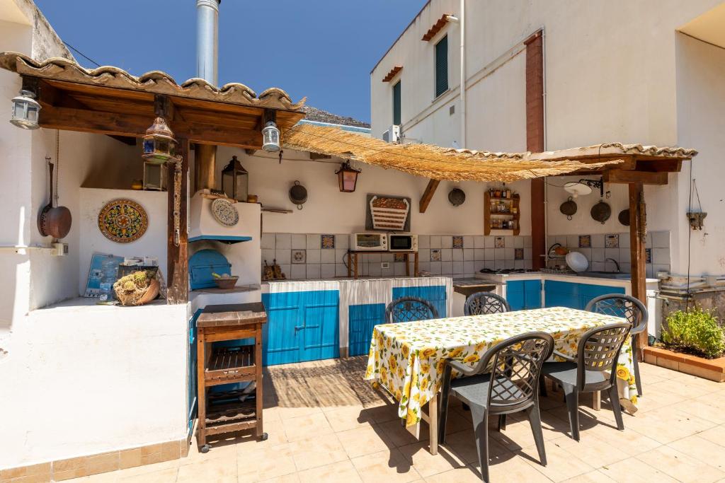 cocina con armarios azules, mesa y sillas en Domus Sicily - Villa Onda en Mondello