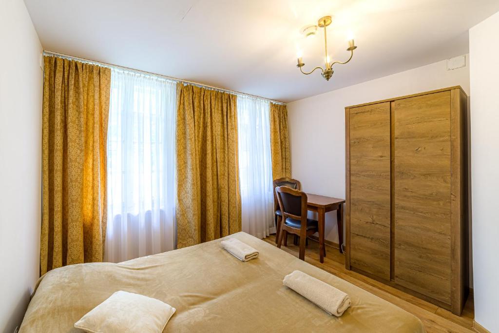 a bedroom with a bed and a desk and a window at Szalay I Szczawnica in Szczawnica