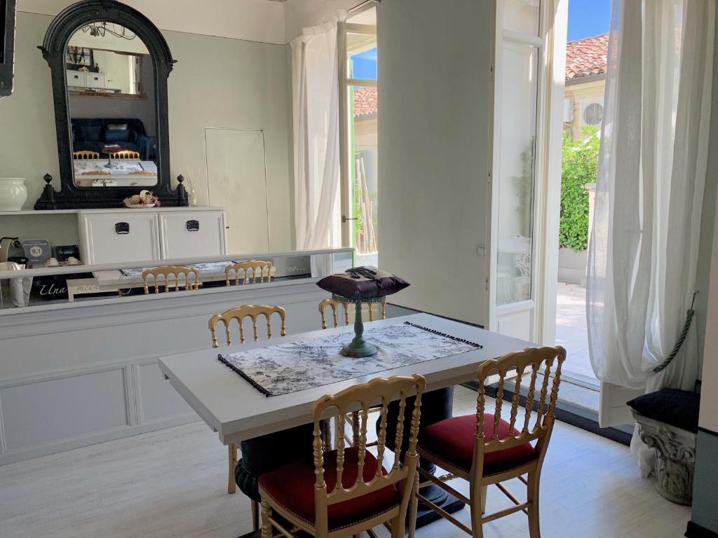 a dining room with a table and chairs and a mirror at Dimora dell'Antico Convento in Alba