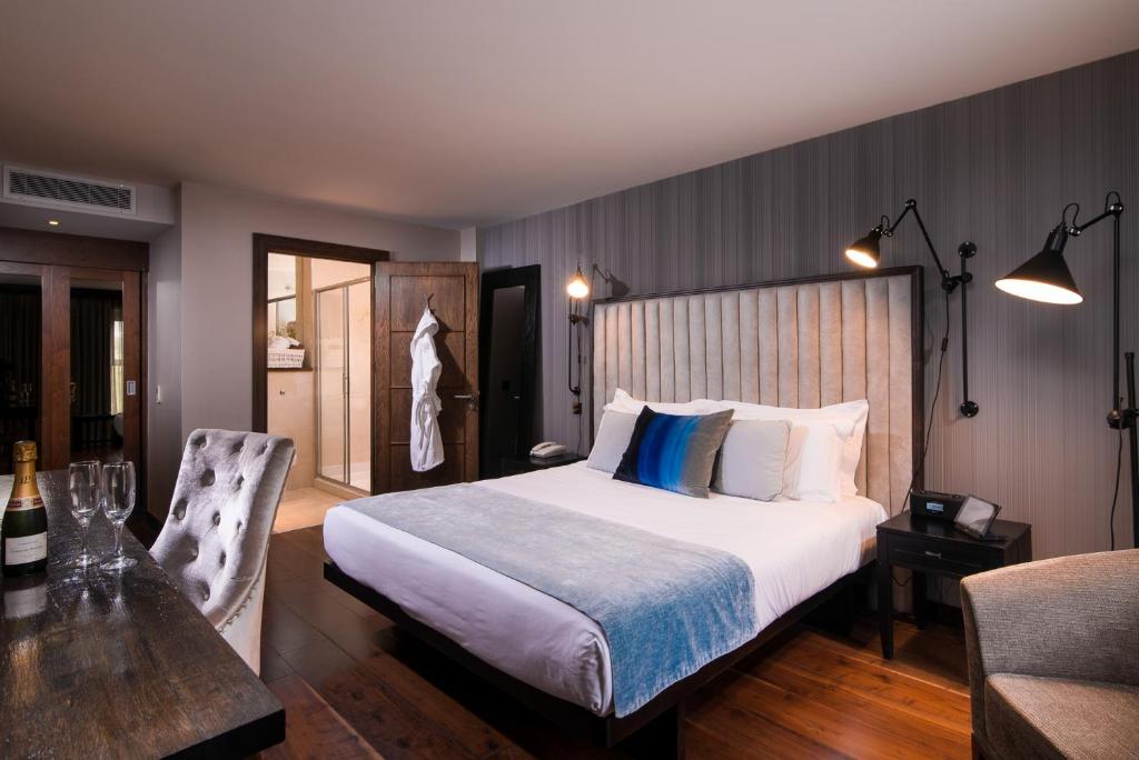 a bedroom with a bed and a table and a chair at The Twelve Hotel in Barna
