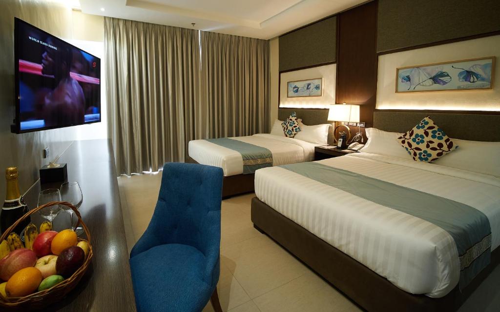 ein Hotelzimmer mit 2 Betten und einer Obstschale in der Unterkunft J7 Plaza Hotel in Iloilo City