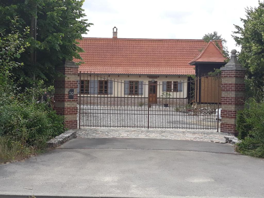 una casa con una puerta y una valla en Au Colombier des Arteaux, en Licques