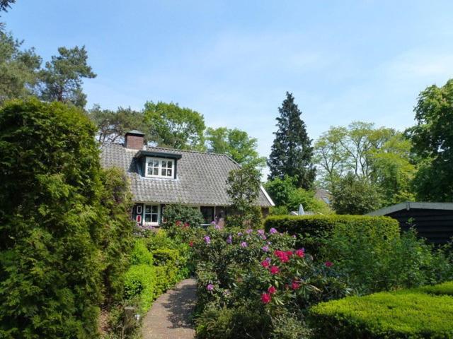 a house with a garden with flowers and bushes at Vakantiewoning Salland in Markelo