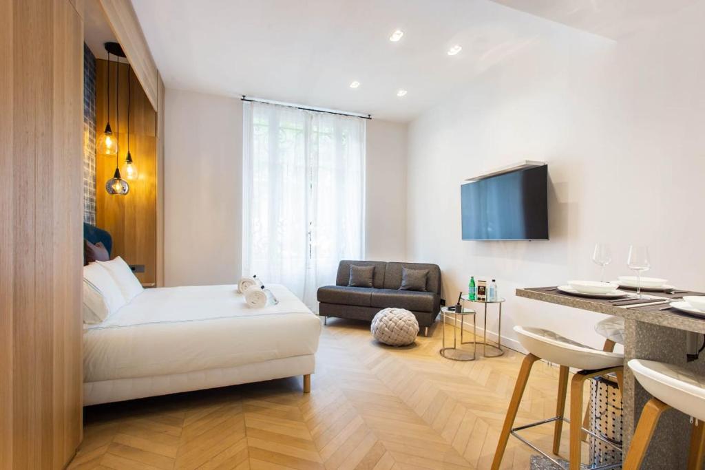 een woonkamer met een bed, een bank en een tafel bij Cosy & Luxury Kléber Trocadéro Arc de Triomphe in Parijs