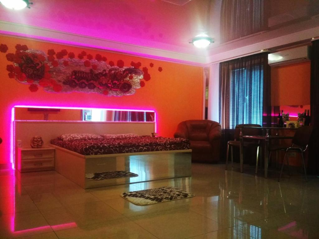 a room with a bed with a pink lighting at Студия in Kryvyi Rih