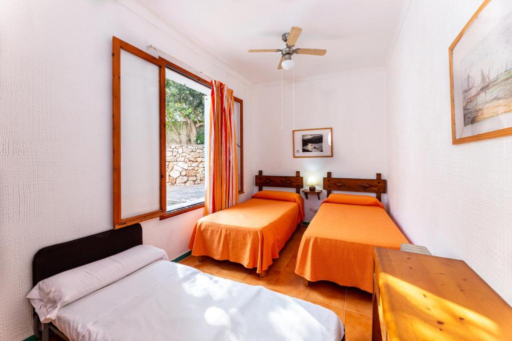 a room with two beds and a couch at Hostal Residencia San Francisco in Portocolom