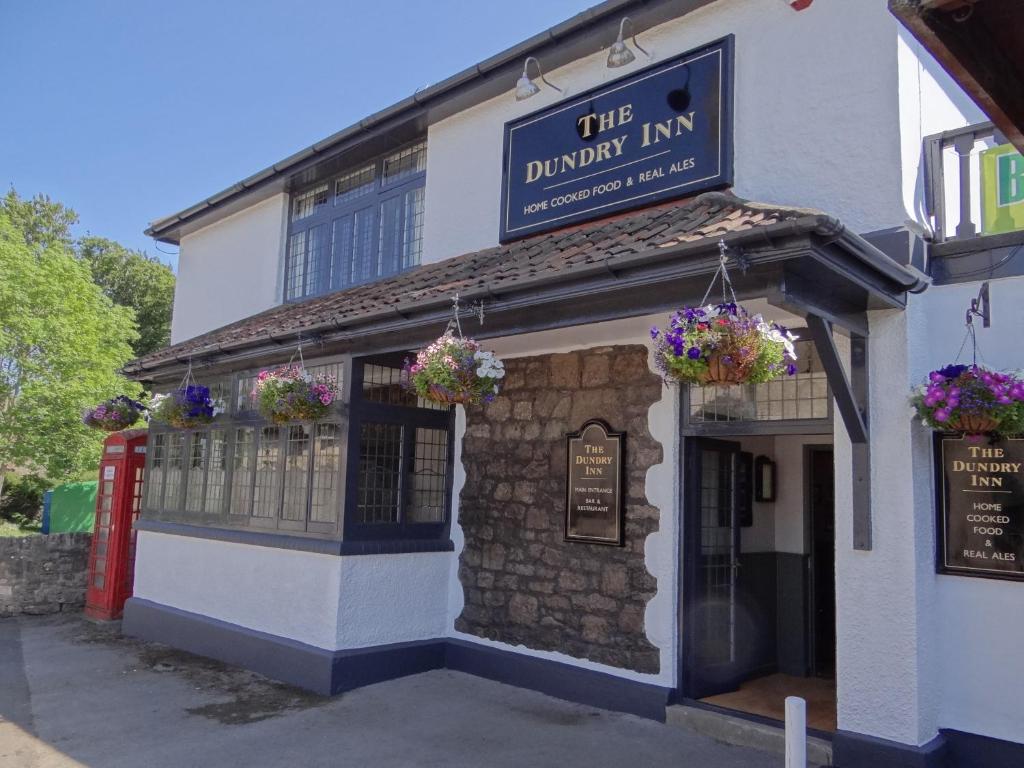 un bâtiment avec un panneau indiquant l'auberge dunedin dans l'établissement The Dundry Inn, à Winford