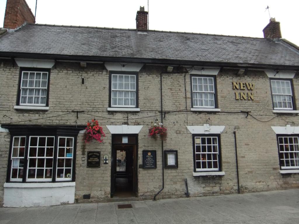 an old brick building with a new hire sign on it at The New Inn in Thornton Dale