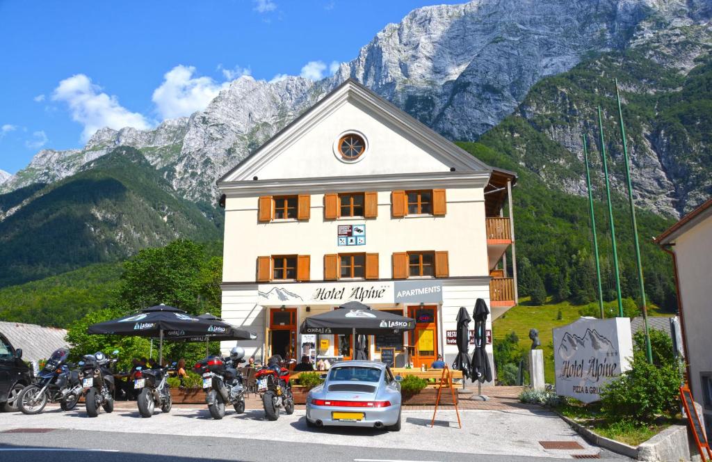 un edificio con un coche aparcado delante de él en Hotel Alpine, en Log pod Mangartom