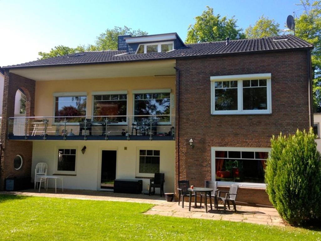 a brick house with a balcony and a patio at Gästehaus Strandkonsulat in Scharbeutz