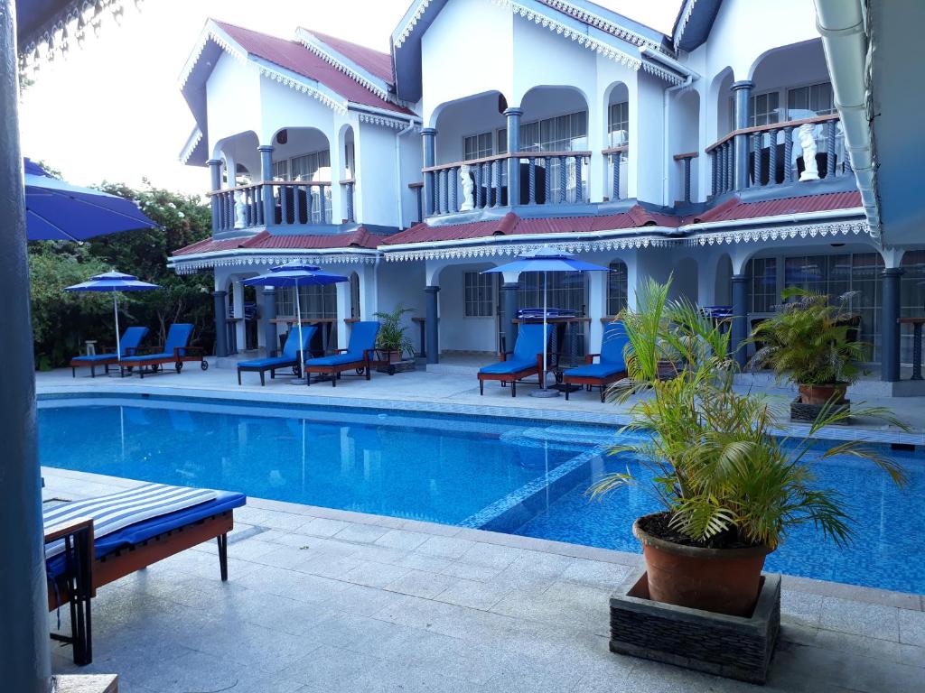 um hotel com piscina em frente a um edifício em Chateau Sans Souci em Grand'Anse Praslin