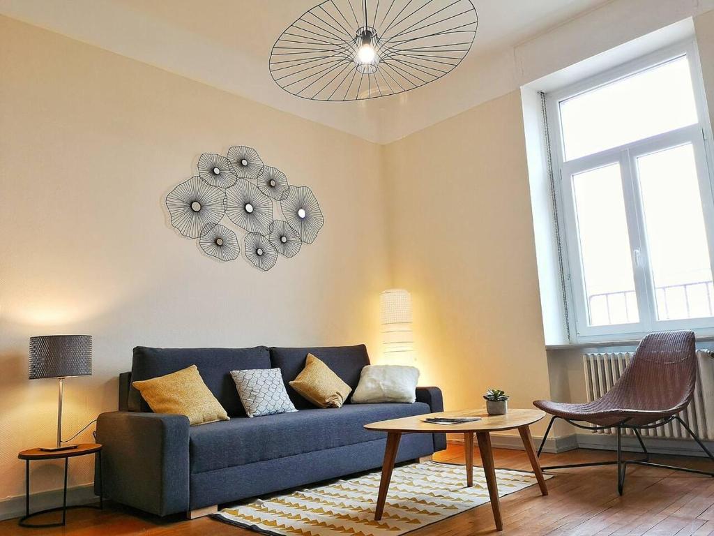 een woonkamer met een blauwe bank en een tafel bij Le XI - Suite Colmar Gare - Parking in Colmar