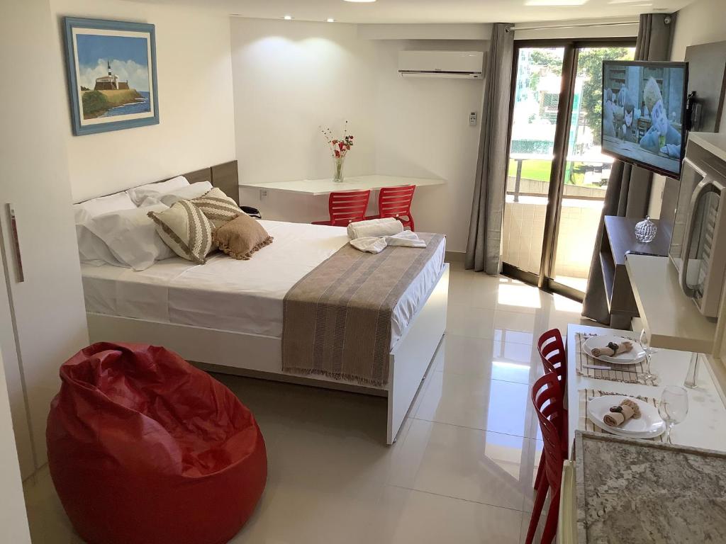 - une chambre avec un lit et un pouf rouge dans l'établissement GoldFlat Cabo Branco - Conforto para sua Família, à João Pessoa
