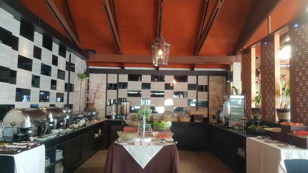 a large kitchen with a table in a restaurant at Montien House - SHA Plus in Chaweng