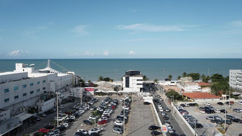 un estacionamiento lleno de coches al lado del océano en Golden Flat en João Pessoa