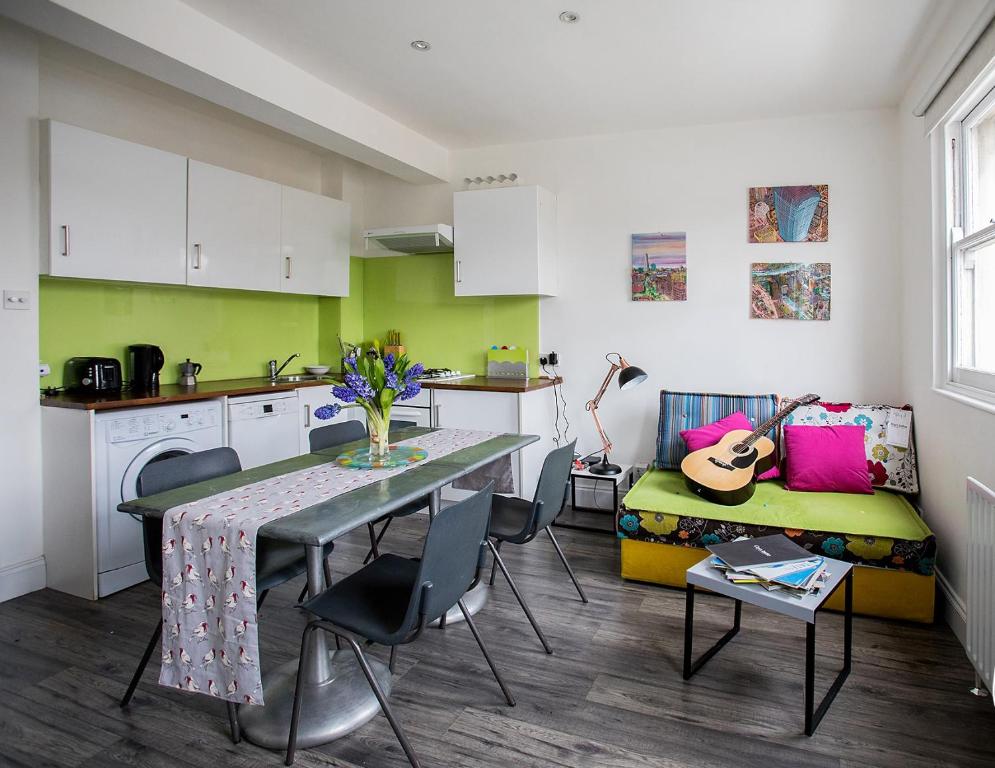 a kitchen and living room with a table and a couch at St Paul 214 in London