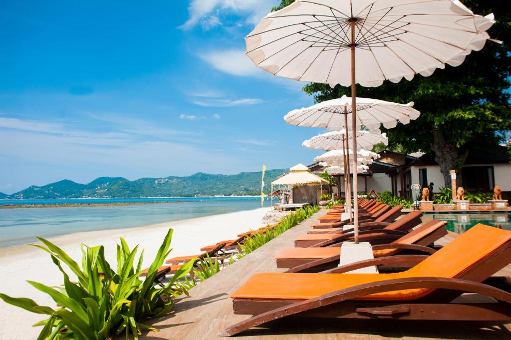Montien House - SHA Plus في شاطئ تشاوينغ: صف من الكراسي والمظلات على الشاطئ