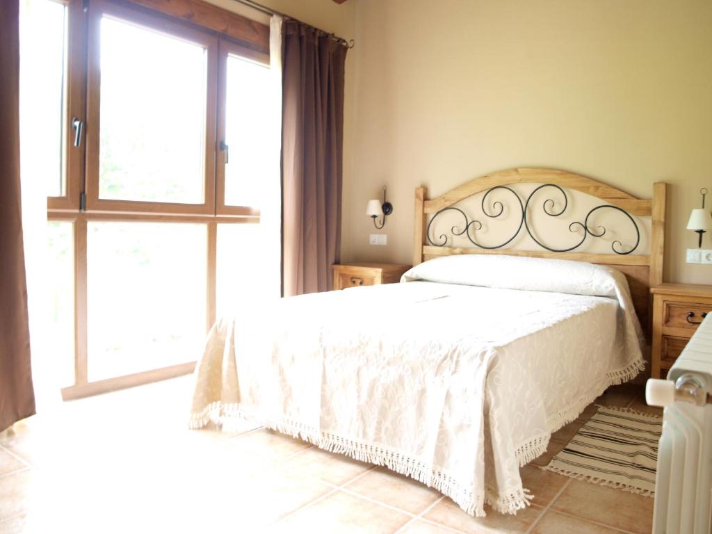 1 dormitorio con 2 camas y ventana grande en Vivienda vacacional La Poza la Braña, en Llanes