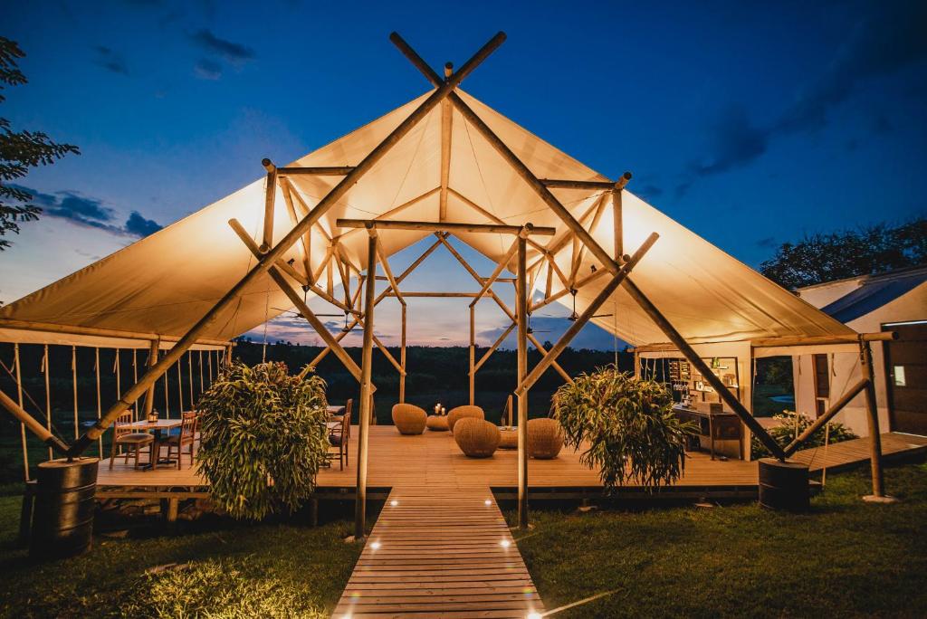 
an outdoor area with chairs, tables, and umbrellas at Glamping Entre Rios in Calarcá
