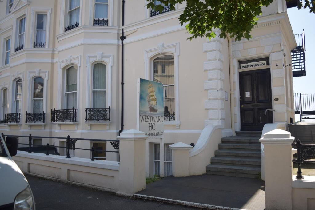 a white building with a sign on the front of it at Westward Ho Hotel in Folkestone