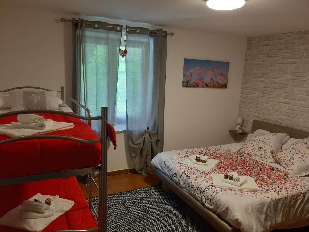 een slaapkamer met 2 bedden en een raam met handdoeken bij CA' VIRASOLELH in Macra