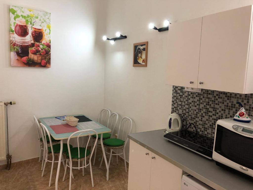 a kitchen with a table and chairs and a microwave at Urania in Budapest