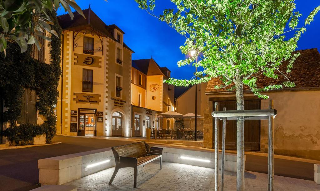 a bench and a tree in the middle of a street at Hôtel Restaurant Famille Bourgeois "La Cote des Monts Damnés" in Sancerre