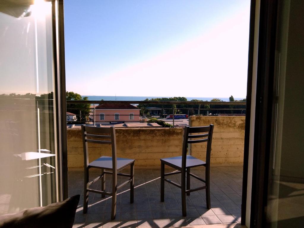 2 sillas sentadas en un balcón con vistas a la ventana en Via Mediterraneo 39 Casa vacanze, en Petacciato