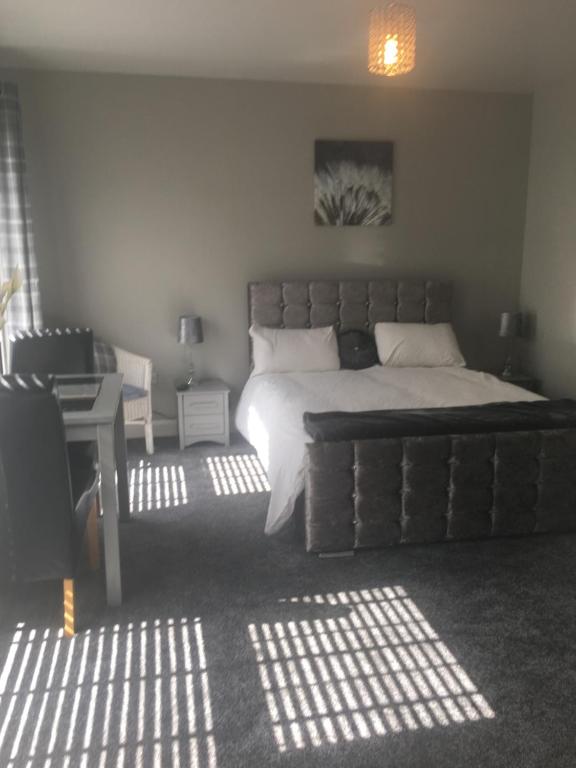 a bedroom with a large bed in a room with sunlight at Country House and Spa in Coleraine