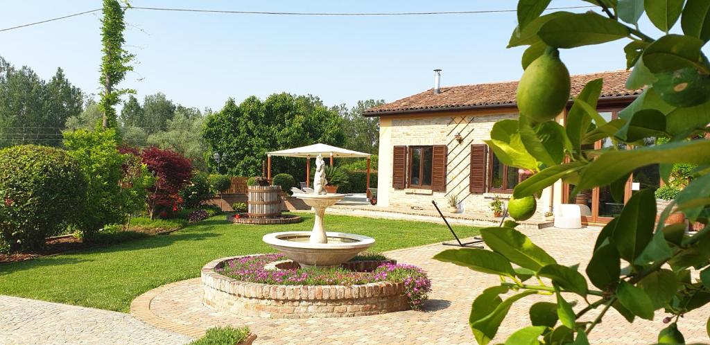 um jardim com uma fonte em frente a uma casa em Villa Vigneto em San Marzano Oliveto