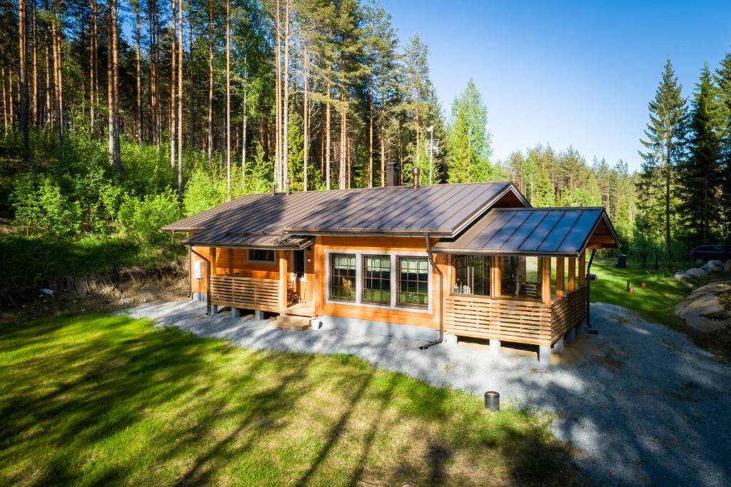 a large wooden cabin in the middle of a forest at Villa Vahtivuori in Rantasalmi