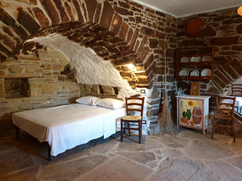 a bedroom with a bed in a stone wall at Casa Contadina in Castelmezzano