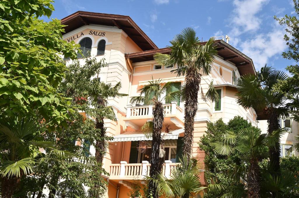a building with palm trees in front of it at Villa Salus, Apartment Maruna in Opatija