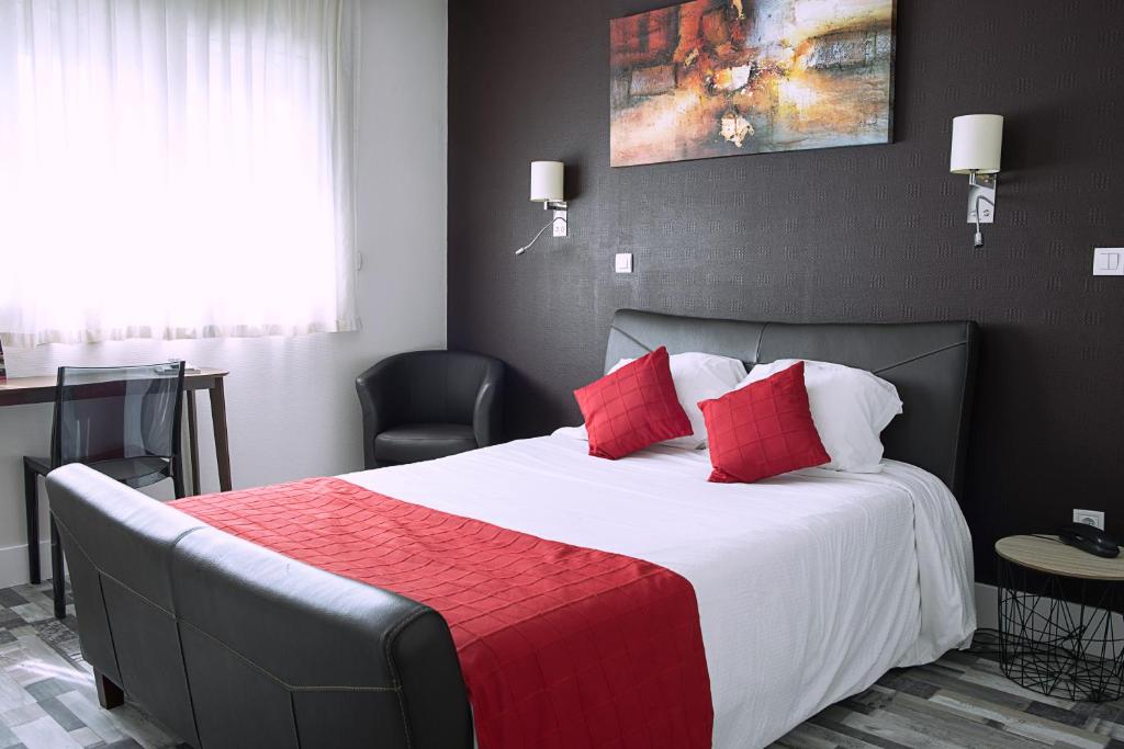 a bedroom with a large bed with red pillows at Cit'Hotel Europeen in Angoulême