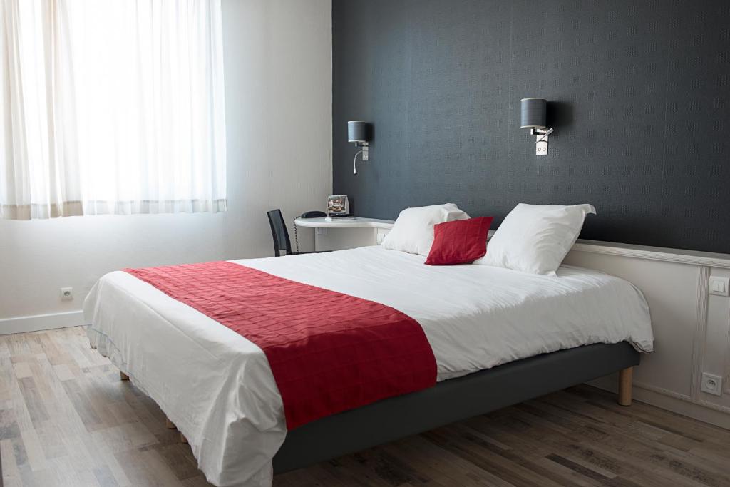 a bedroom with a large bed with a red blanket at Cit&#39;Hotel Europeen in Angoulême