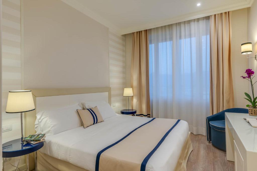 a hotel room with a large bed and a window at Grand Hotel & Riviera in Lido di Camaiore