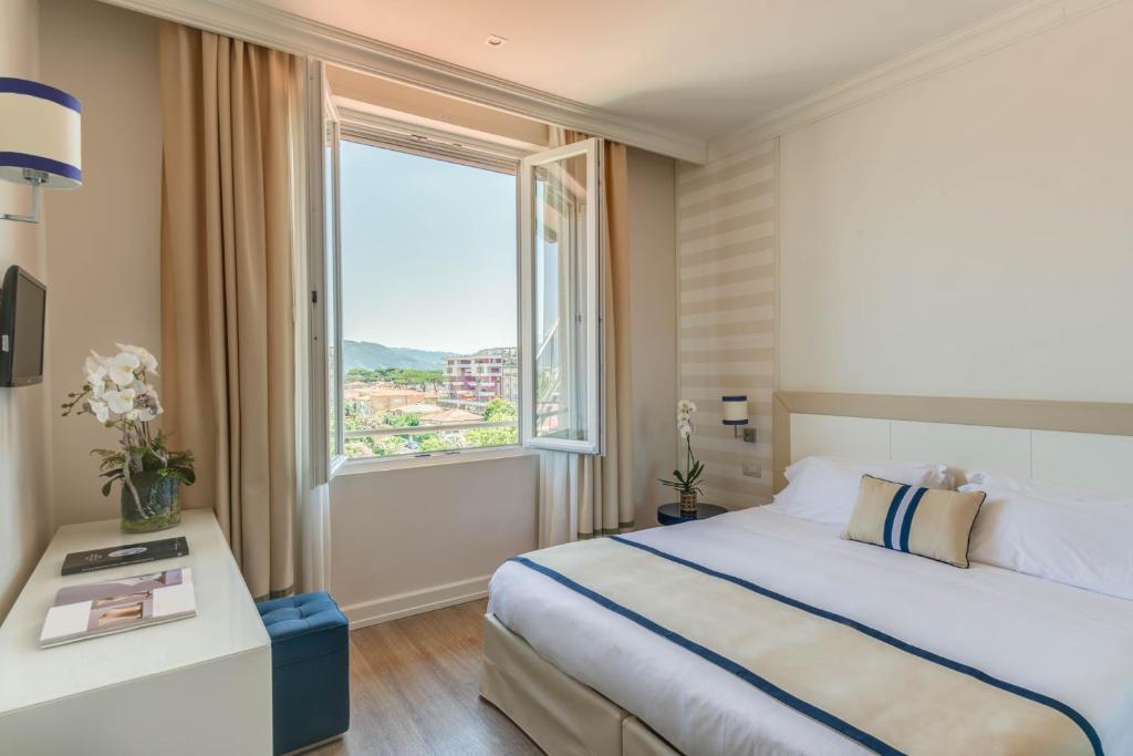 a hotel room with a bed and a large window at Grand Hotel & Riviera in Lido di Camaiore