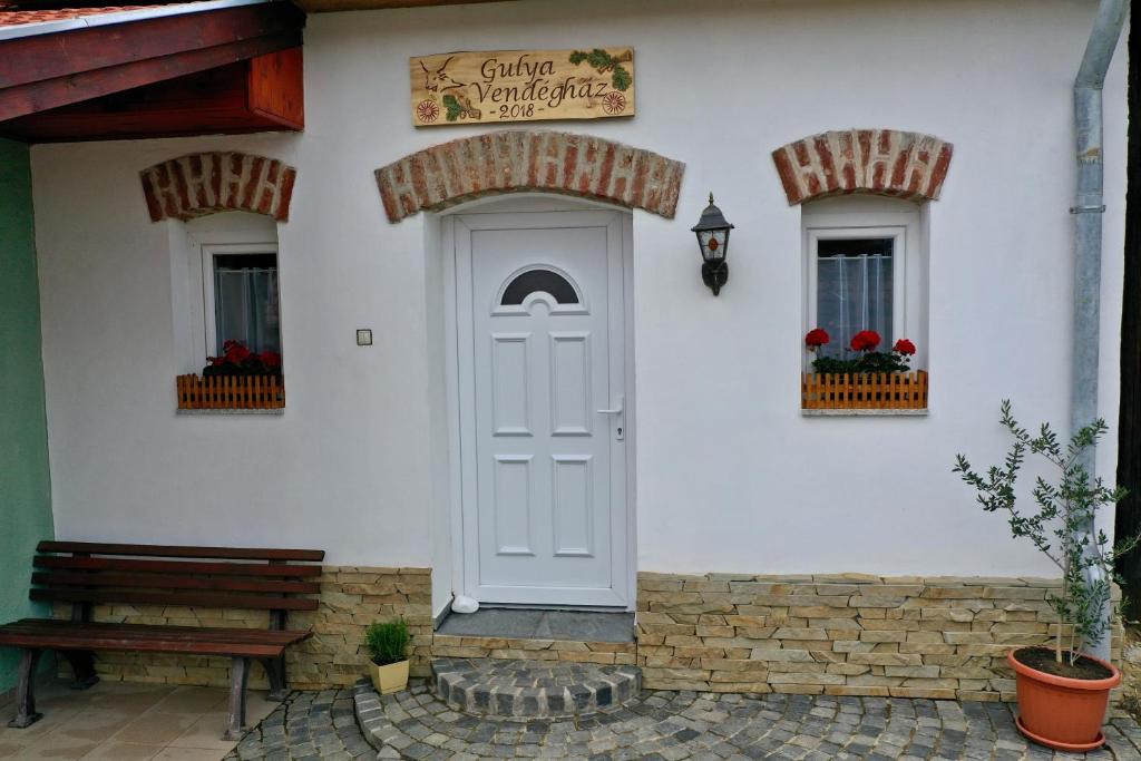a white building with a white door and two windows at Gulya Vendégház in Zalalövő