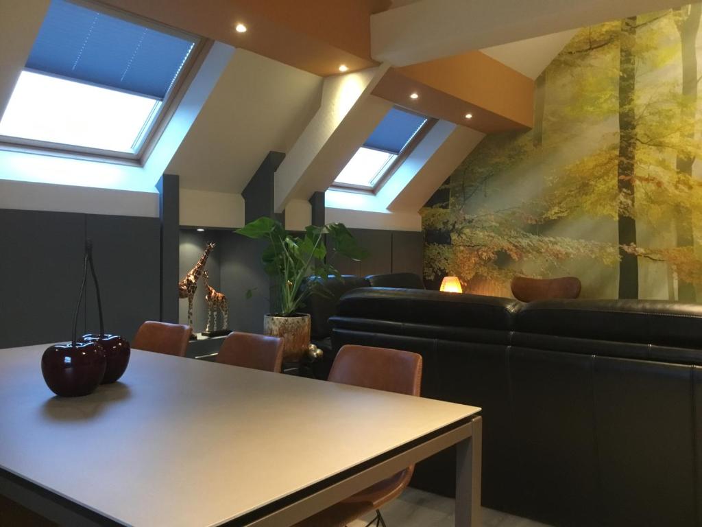 een woonkamer met een tafel en een bank bij Villa Schoon in Geraardsbergen