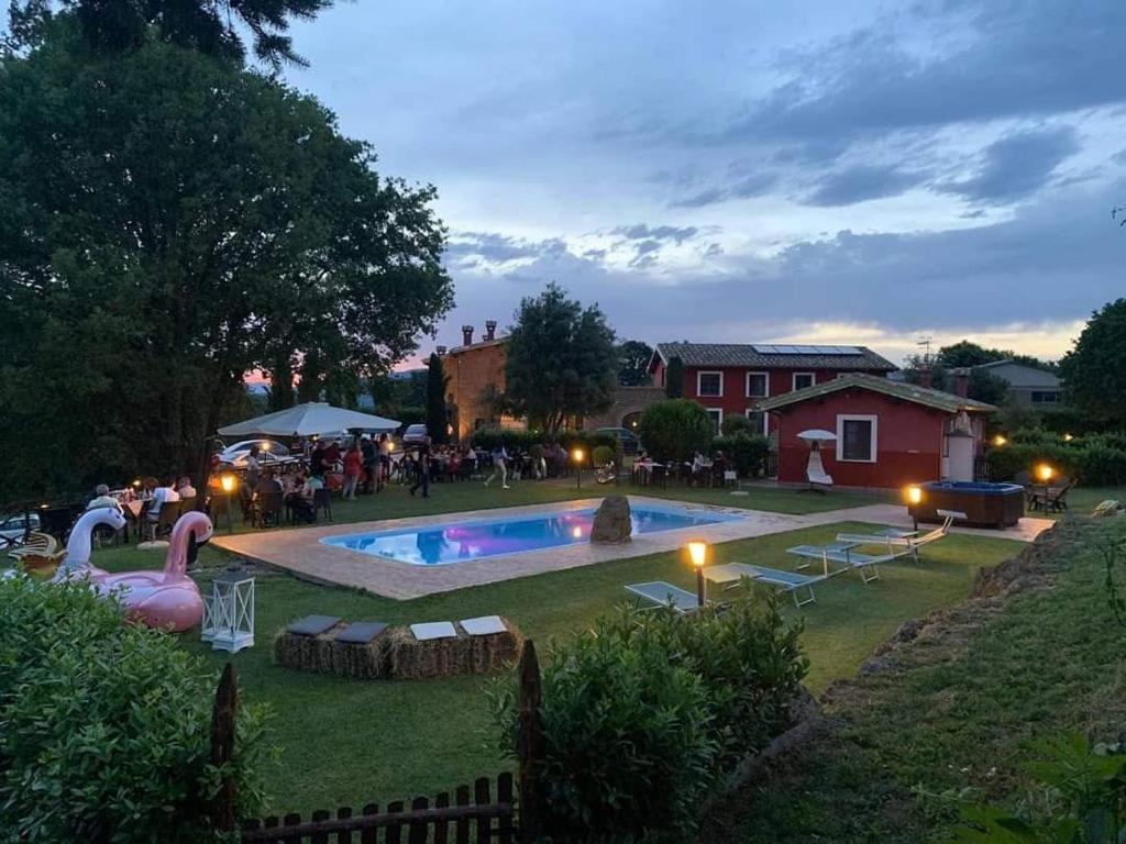 a backyard with a swimming pool and a group of people at Agriturismo Podere Del Lepre in San Quirico