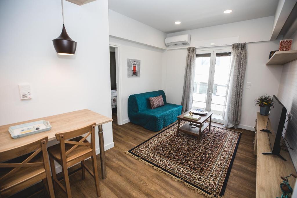 uma sala de estar com um sofá azul e uma mesa em Ziva Apartment - 4th floor - Renovated 2019 em Atenas