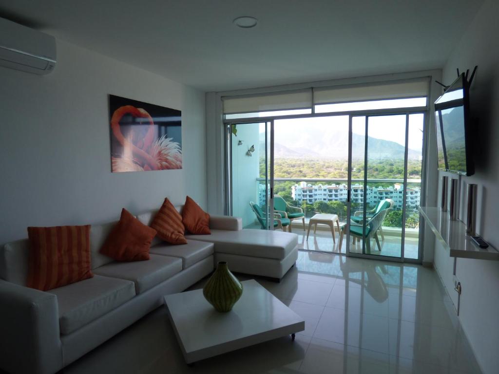 ein Wohnzimmer mit einem Sofa und einem Tisch in der Unterkunft Costa Azul Suites 906 in Santa Marta