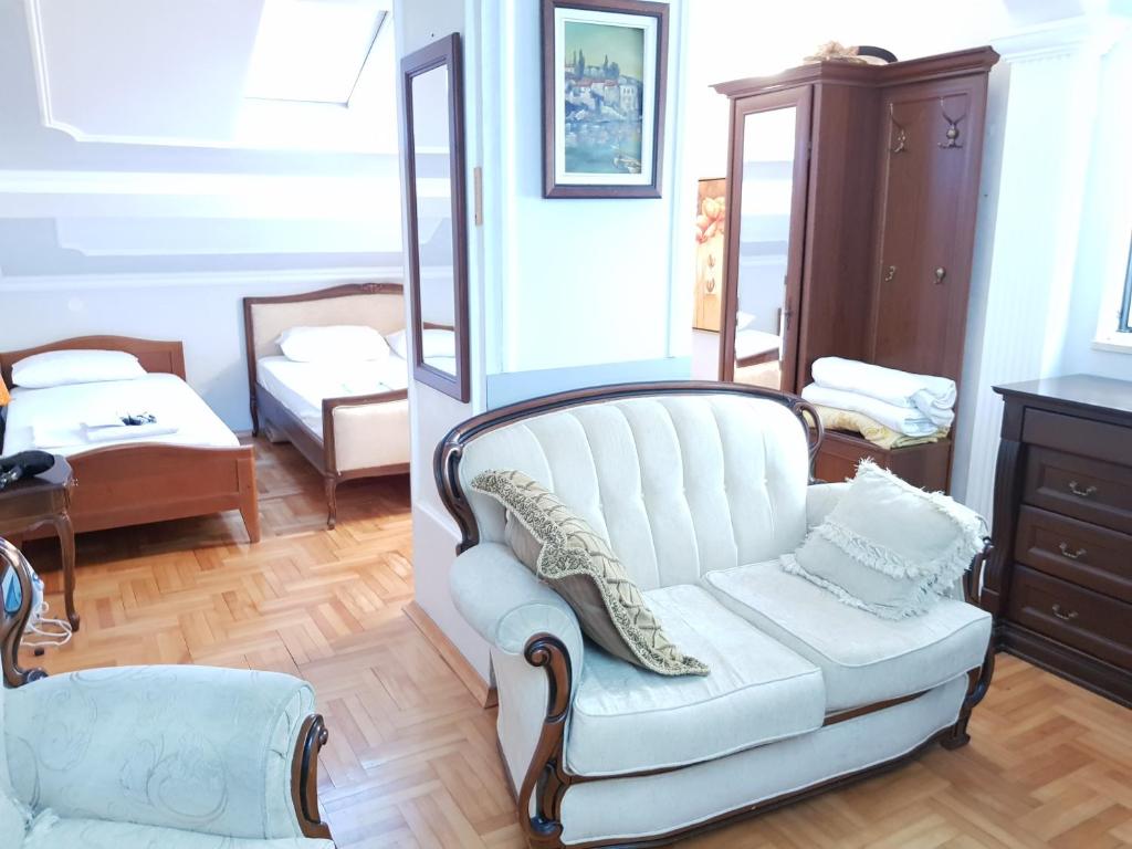 uma sala de estar com um sofá branco e um espelho em Emi em Budva
