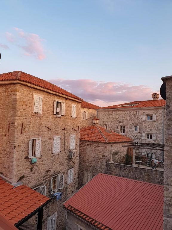 a group of brick buildings with red roofs at Old Town Point in Budva