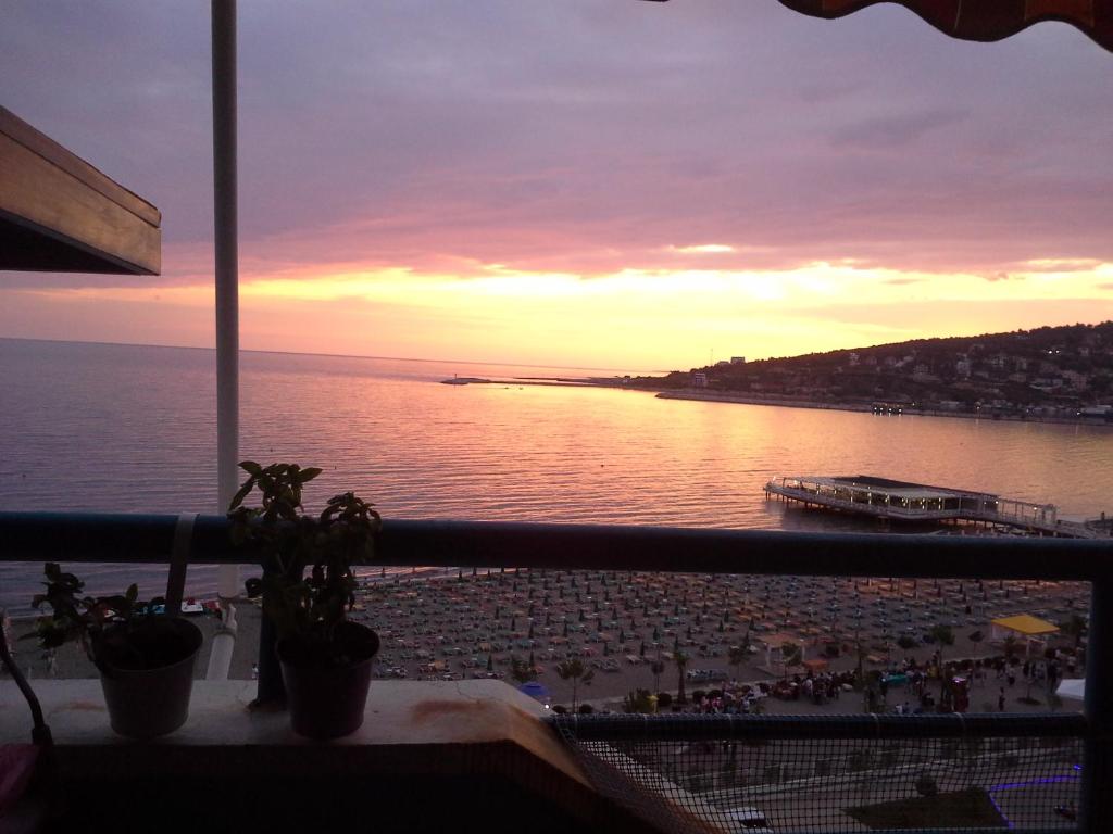 a view of the ocean at sunset from a balcony at Nada SeaView Apartment in Shëngjin