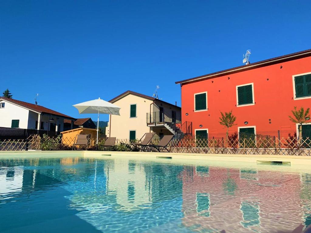 uma piscina em frente a dois edifícios e uma casa em Liguria Village em Brugnato