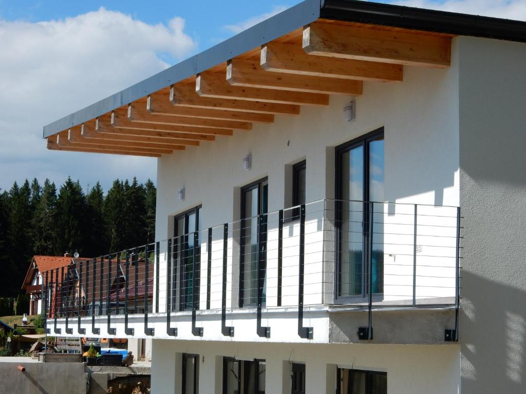 a building with a balcony with awnings on it at Apartmány U Evy in Lipno nad Vltavou